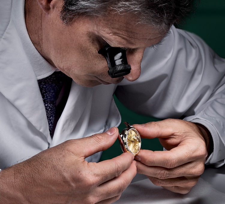 Rolex jeweler inspecting watch with a loupe