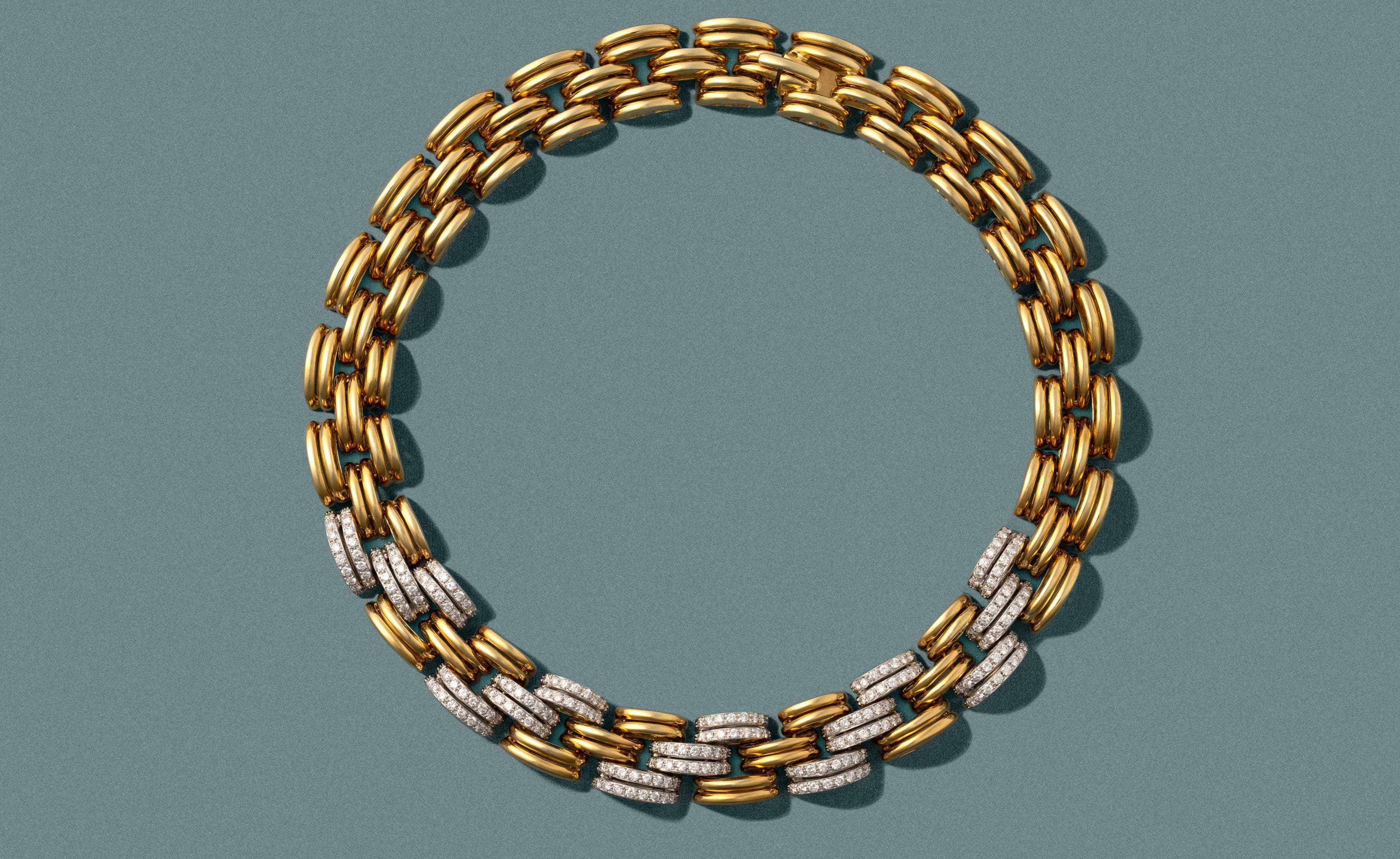Gold and silver chain necklace on a green gray background