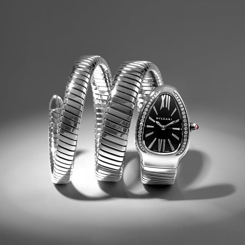 Silver Bvlgari watch with snake-like design on a gray background