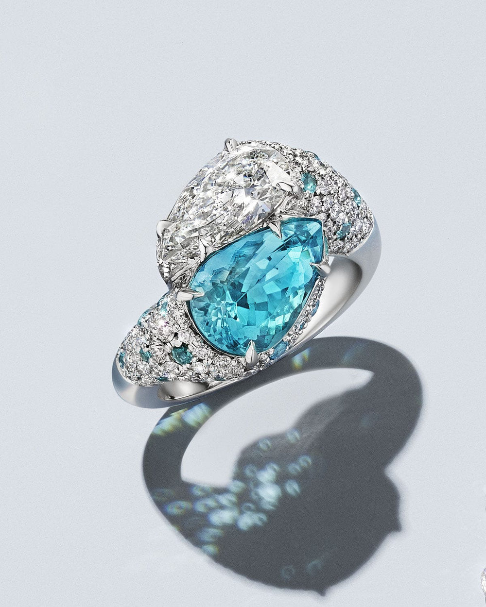 Ring with a blue gemstone and diamond accents on a light gray background