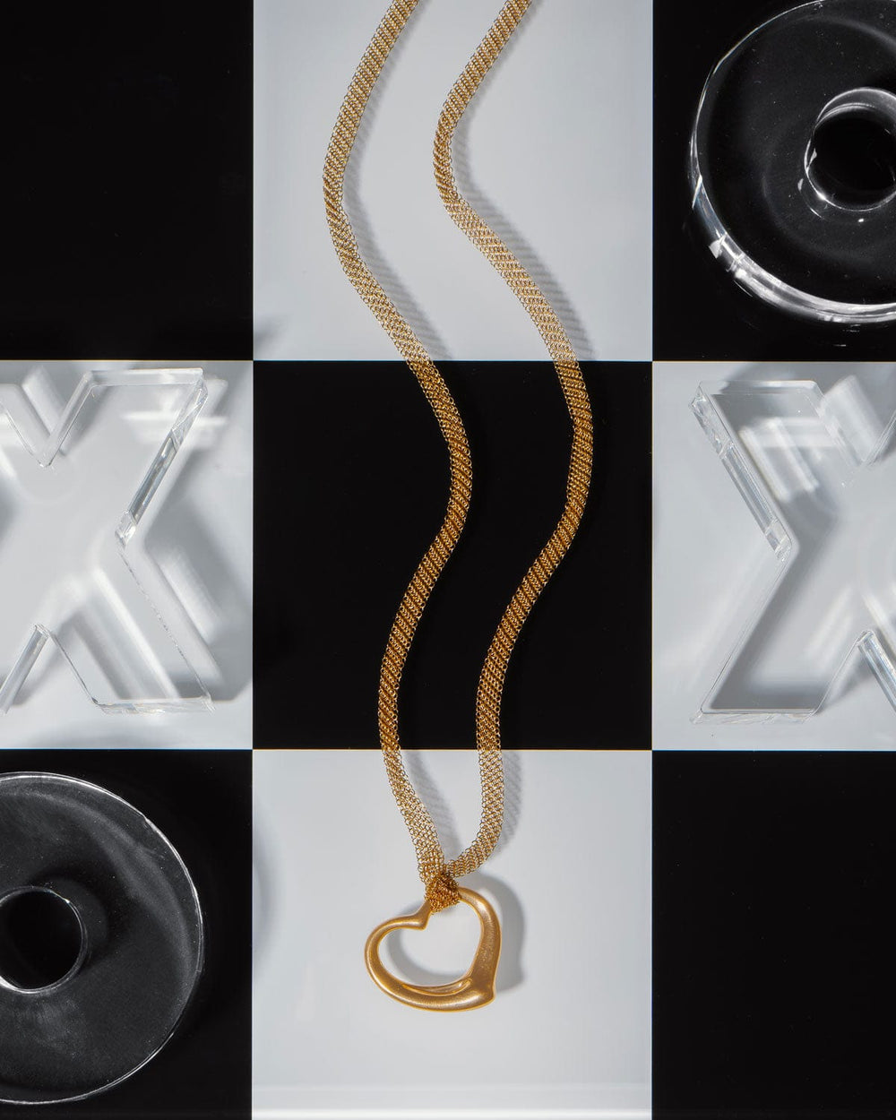 Gold estate Tiffany & Co. necklace with a heart-shaped pendant on a checkered background
