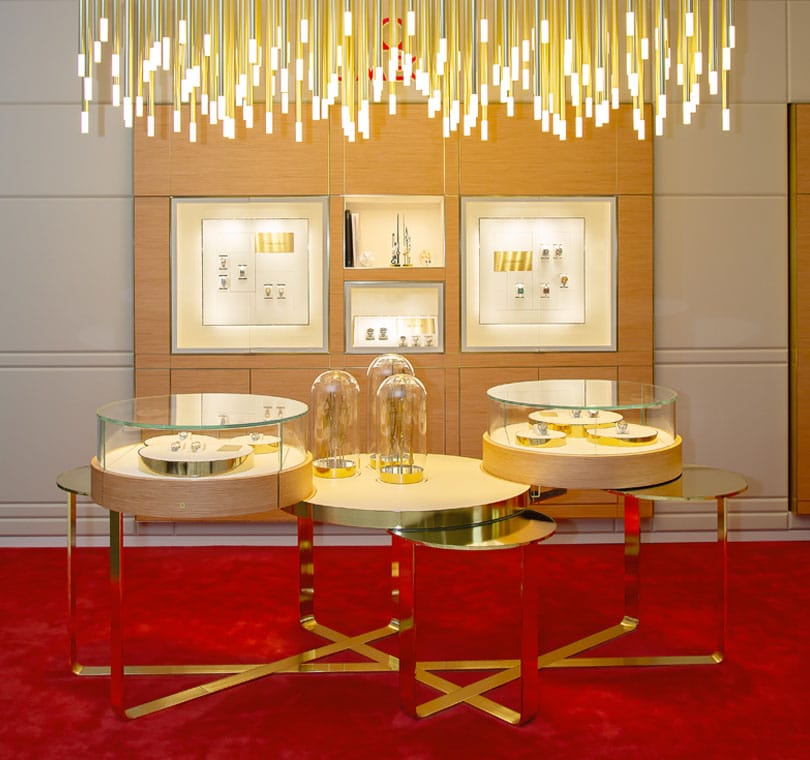 OMEGA watch display with glass cases and gold accents in a high-end store setting.