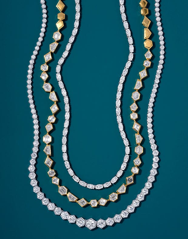 Three diamond necklaces with gold accents on a dark blue background