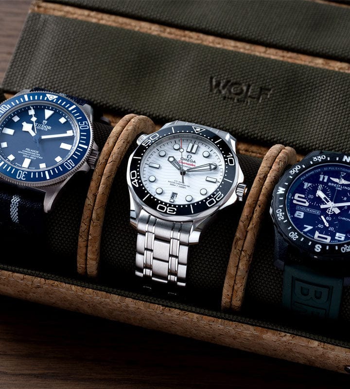 Three watches displayed on a brown leather strap with 'WOLF' branding.