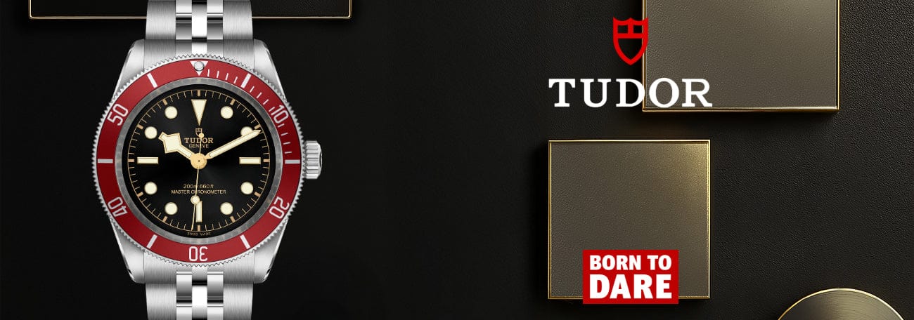 Tudor watch with red bezel and silver case on a black background, featuring the Tudor logo.