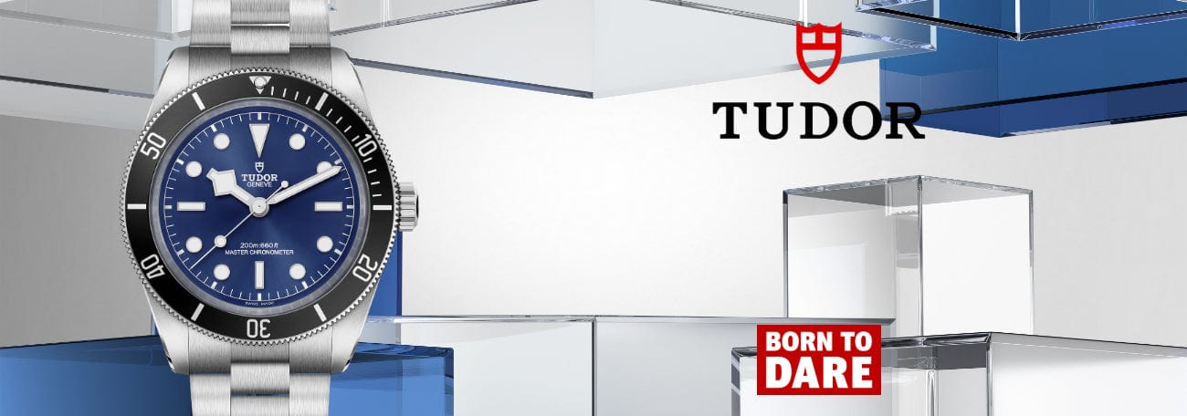 Tudor watch with blue face and silver case on a modern background