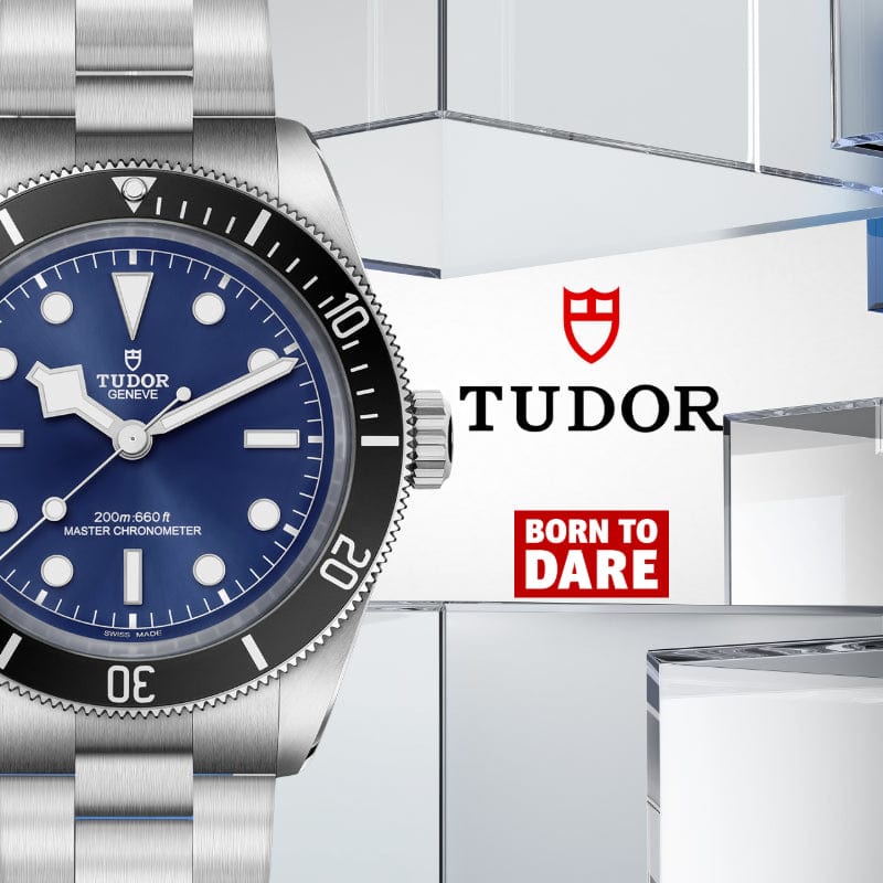 Tudor watch with blue dial and silver strap on a white background with Tudor logo.