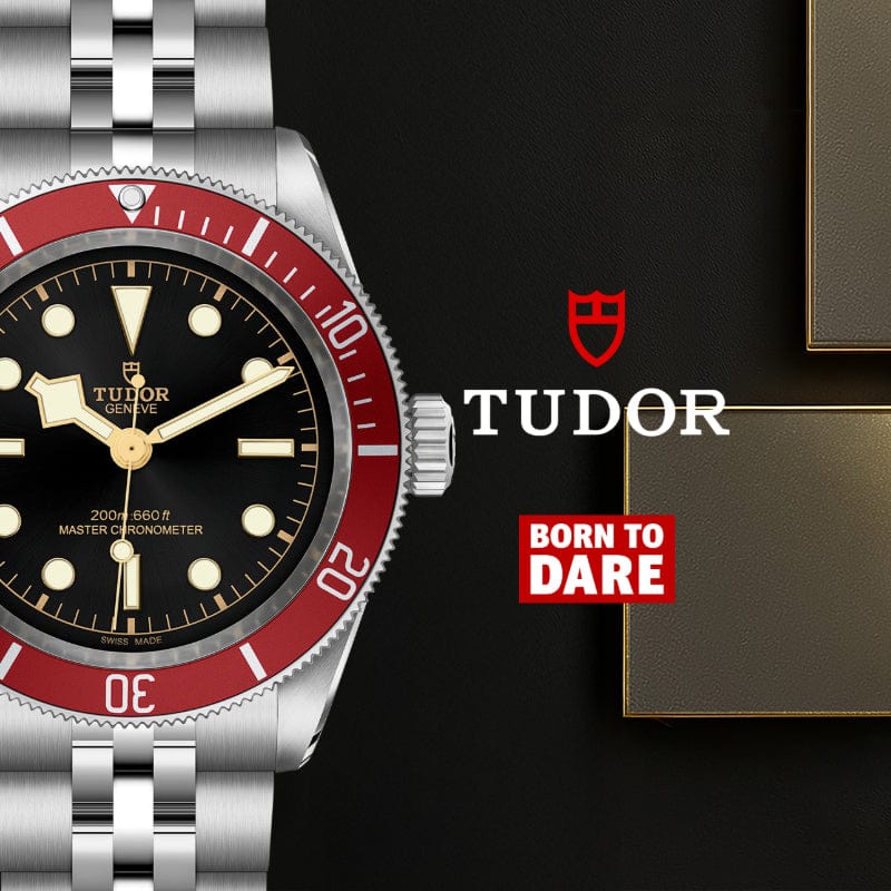Tudor watch with red bezel and black dial on a dark background, featuring the Tudor logo and 'Born to Dare' slogan.
