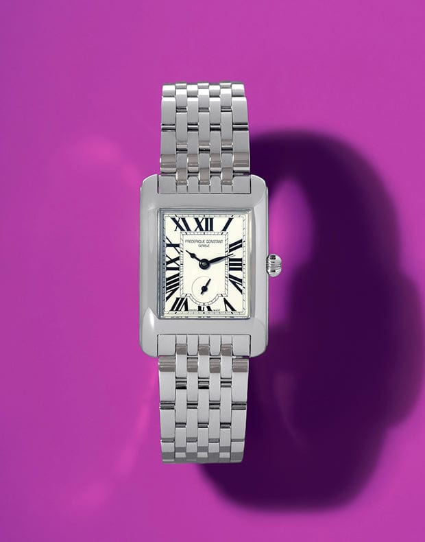 Silver watch with a white face on a purple background