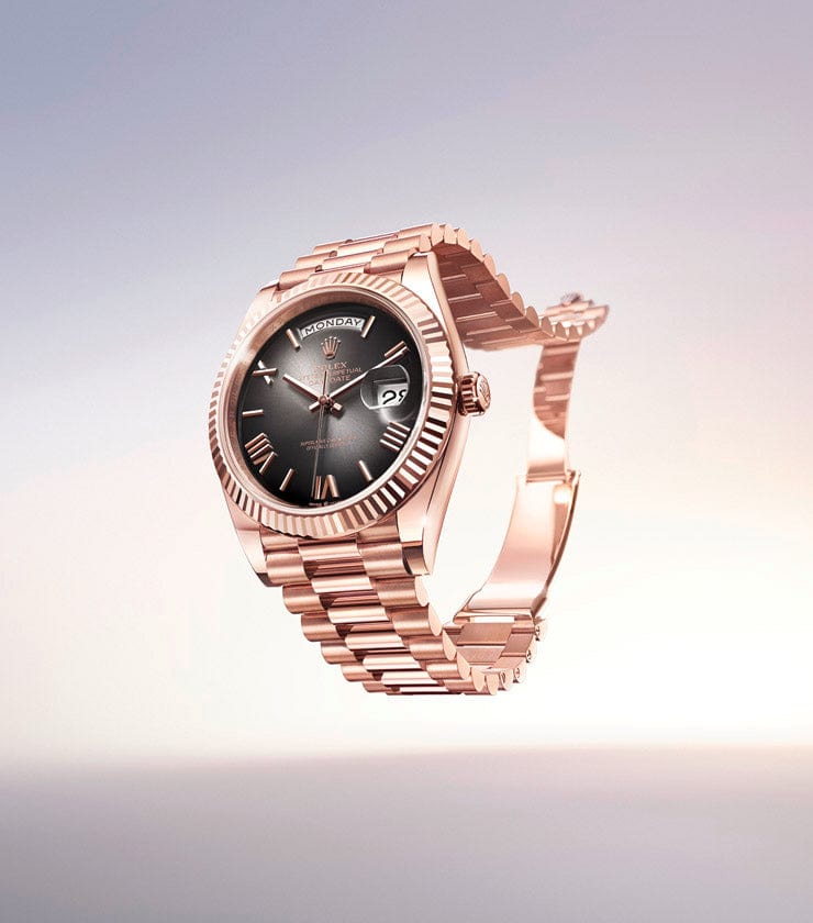 A luxurious gold wristwatch with a black face and gold numerals is displayed in an elegant, gradient-lit background. The timepiece features a day and date display and a detailed, intricate band.