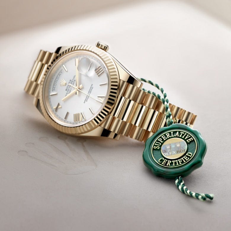 A gold luxury wristwatch with a white dial and Roman numeral markers is positioned stylishly. The watch features a fluted bezel and is accompanied by a green tag labeled 
