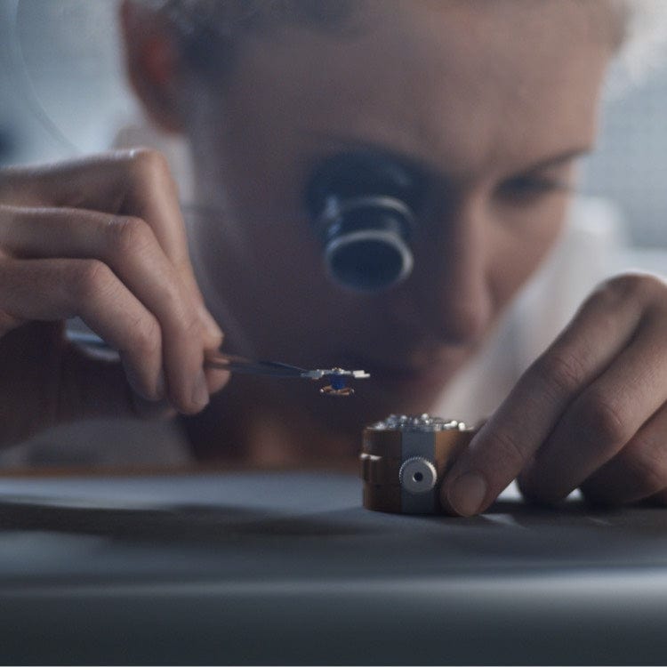 Jeweler inspecting a watch with a loupe