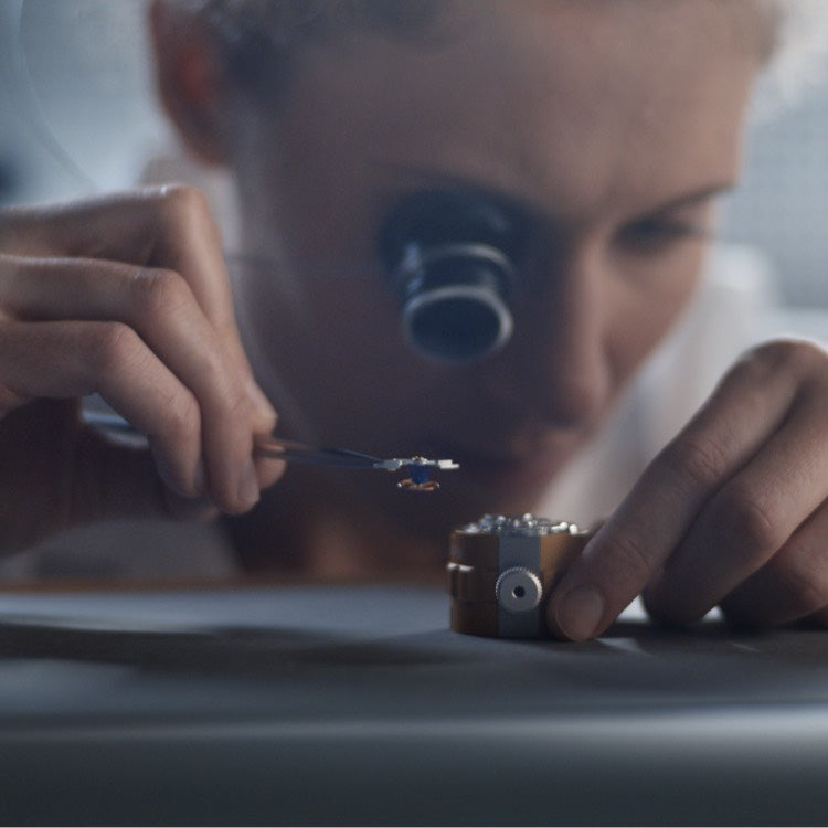 Jeweler inspecting a watch with a loupe