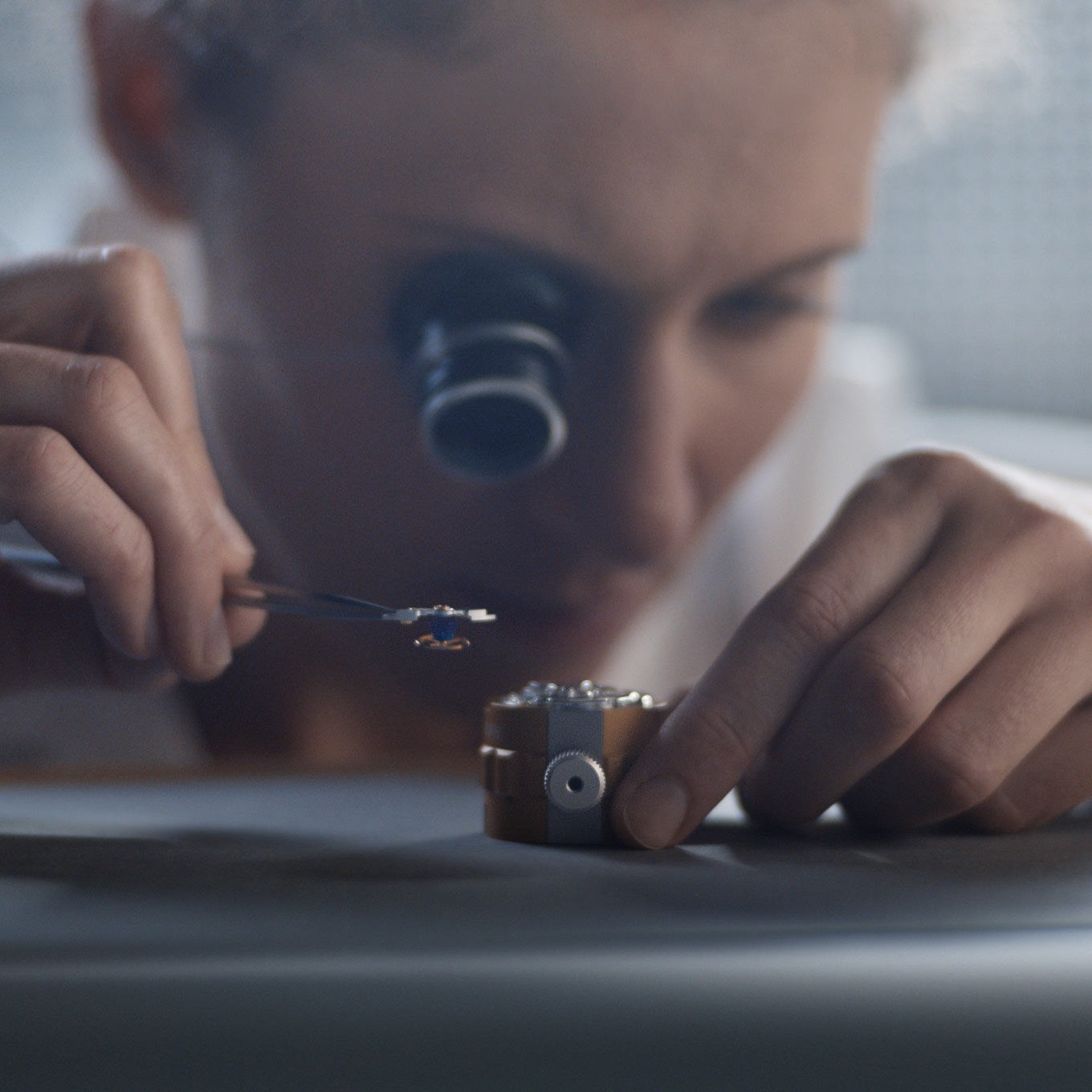 Jeweler inspecting a watch with a loupe